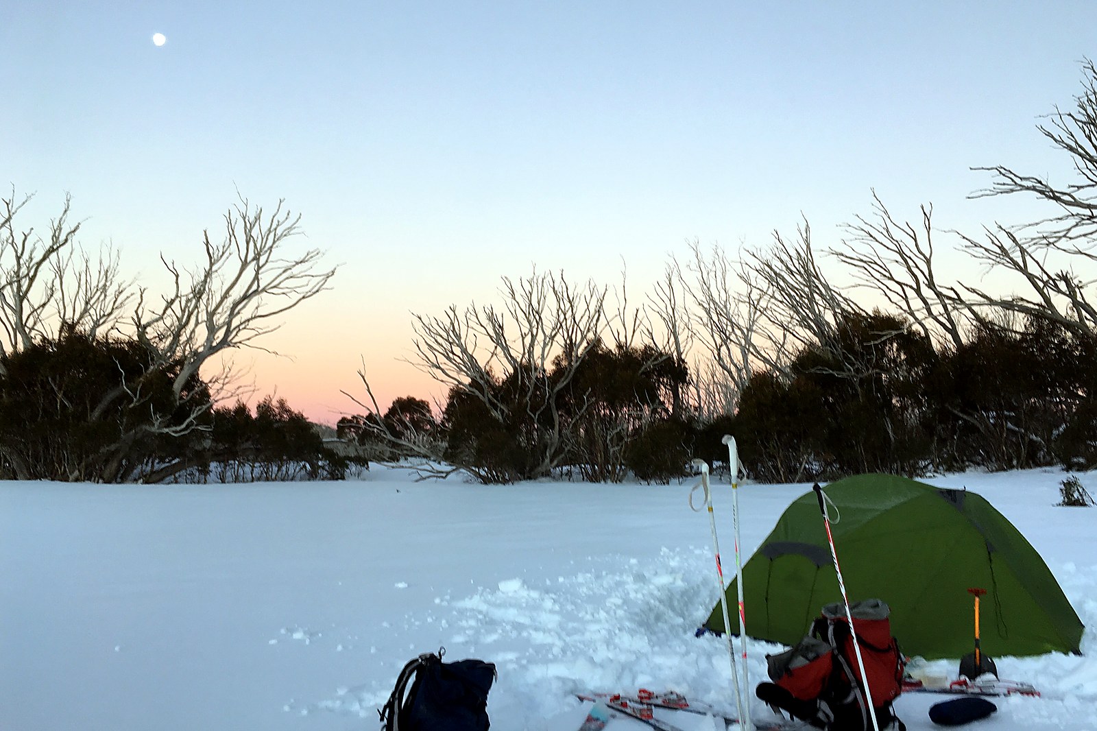 Three-person tent set up in snow
